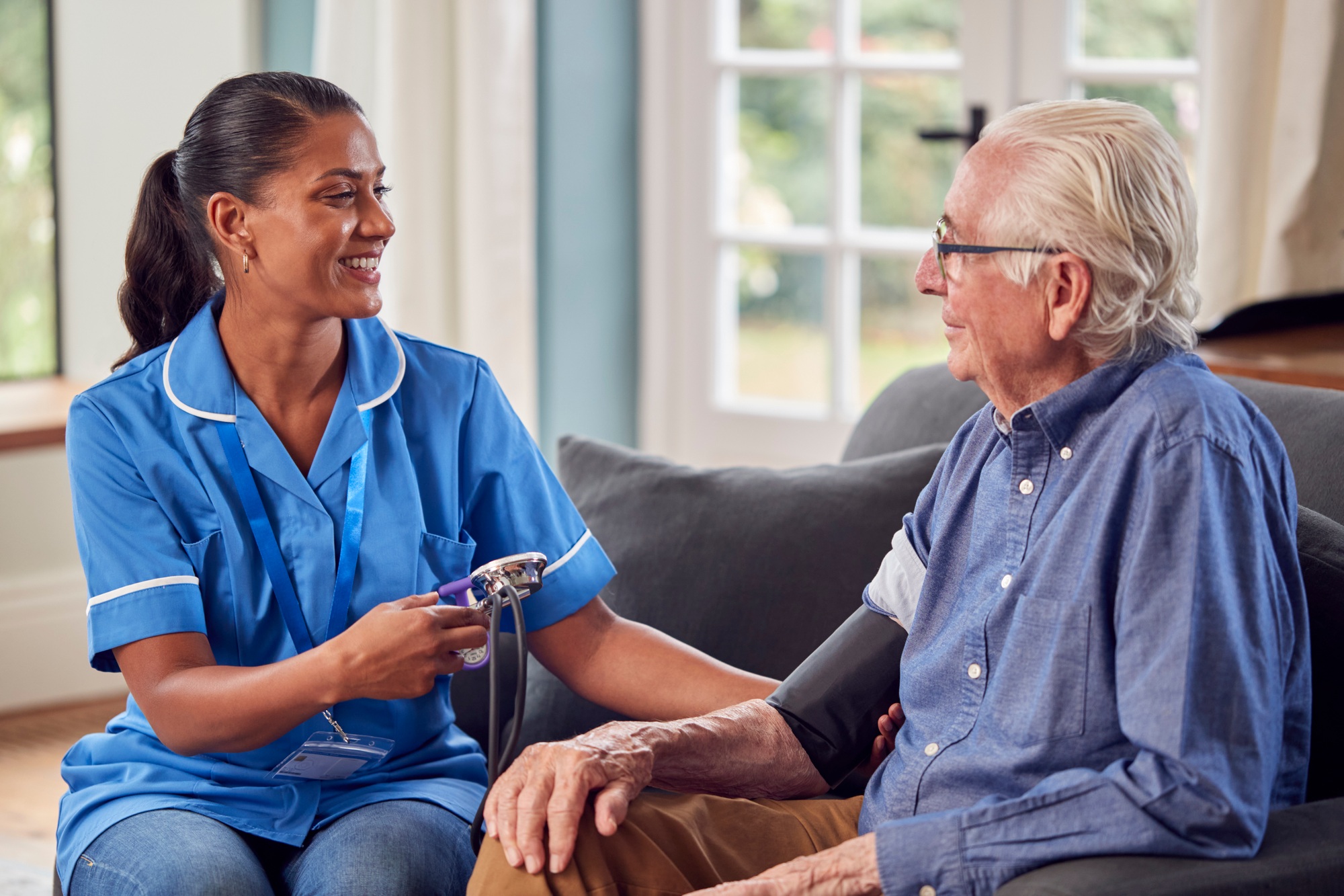 Educational Tips 70 Senior Man At Home In Lounge Having Blood Pressure Taken By Female Care Worker In Uniform